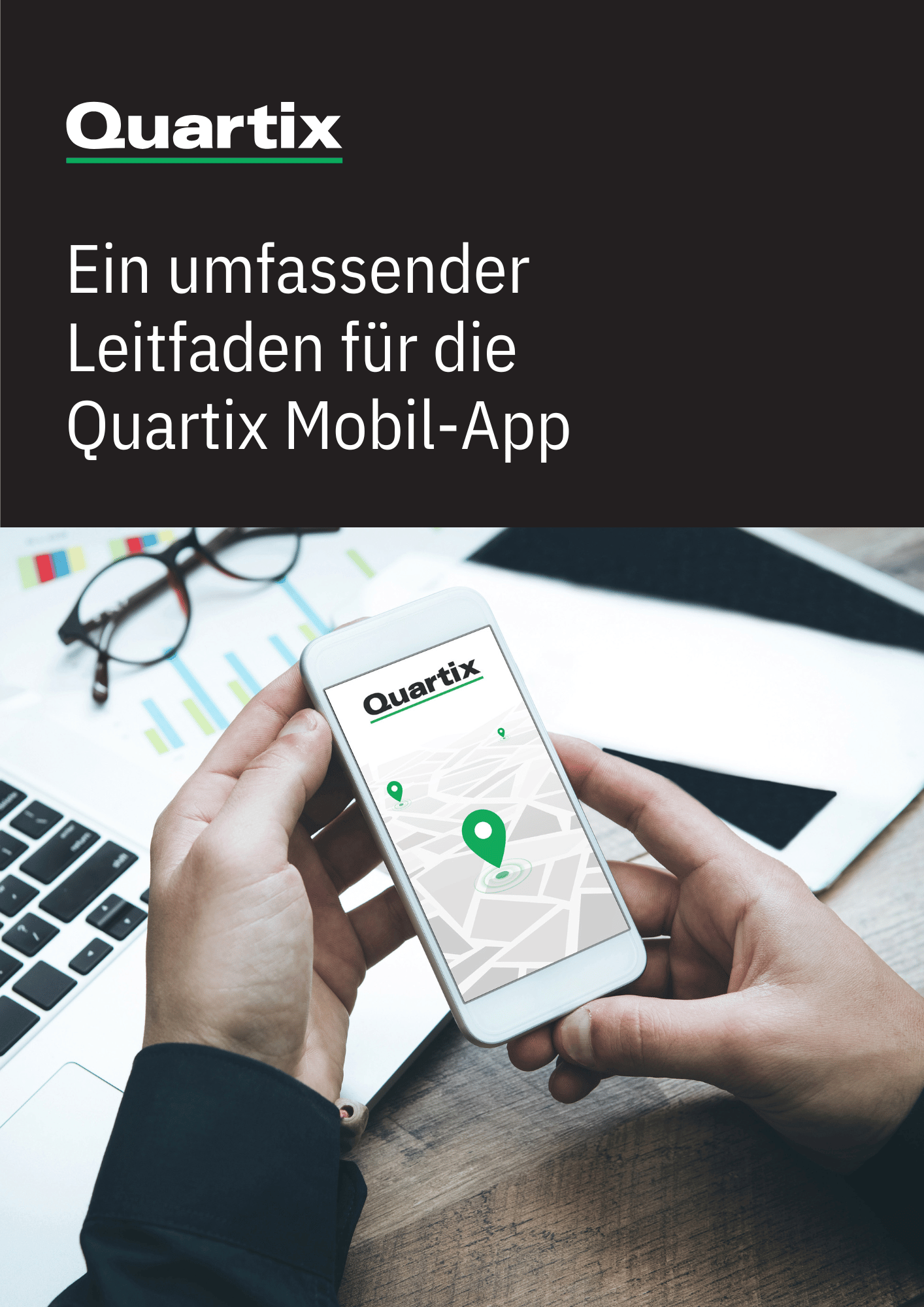 A person holds a smartphone displaying a map with a location pin and the Quartix logo, next to a laptop, notebook, and glasses on a desk.